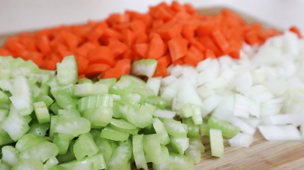 chopped celery, carrot and onion on a cutting board