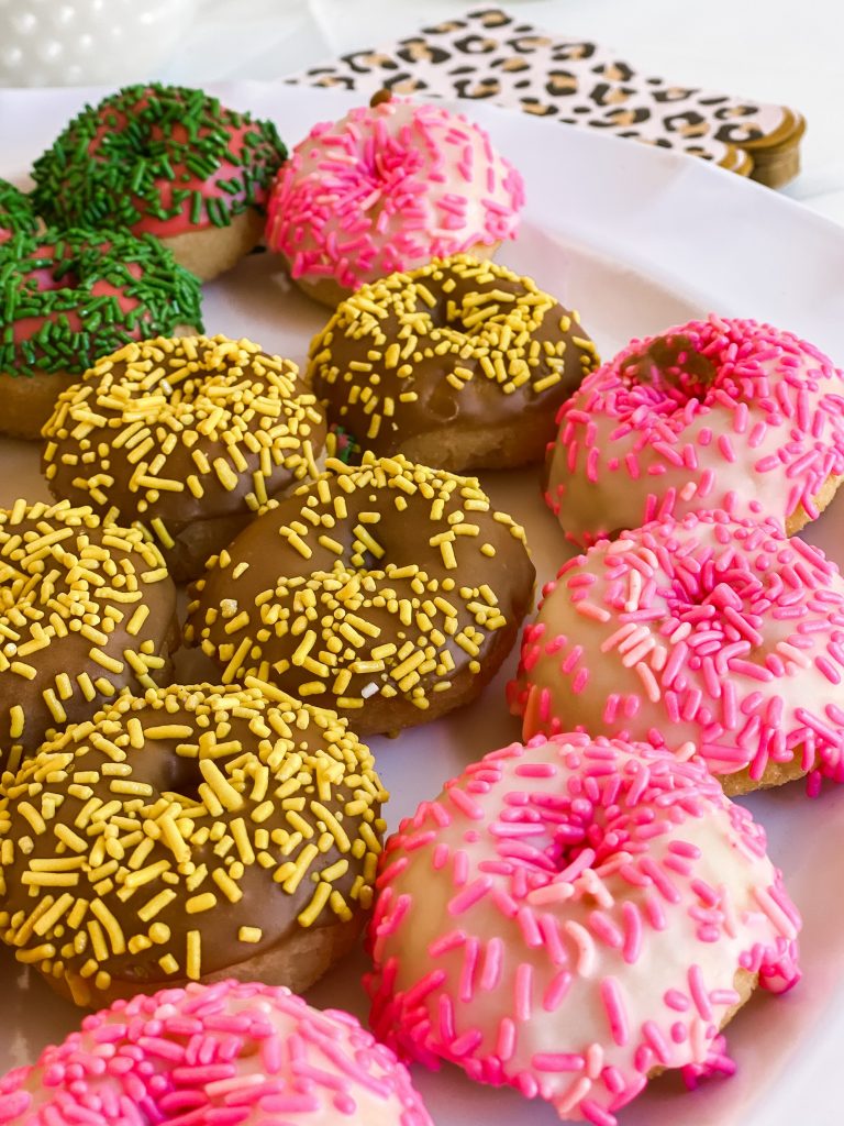 Mini donuts with sprinkles sitting on a tray