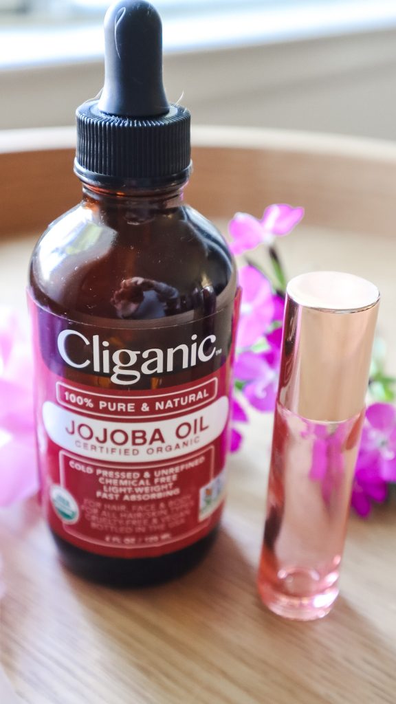 A bottle of jojoba oil next to a bottle of DIY cuticle oil